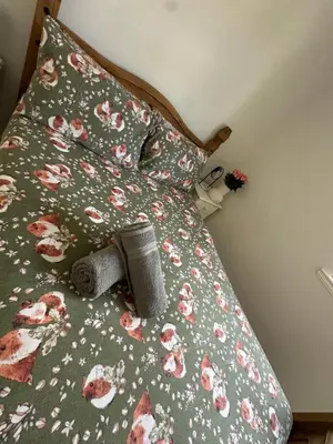 a bed with a green comforter with flowers on it at Old Town Place in Edinburgh