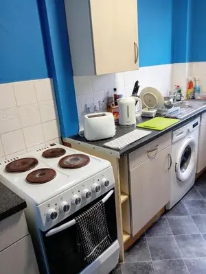 a kitchen with a stove and a washing machine at Pokój 1osobowy in Moffat