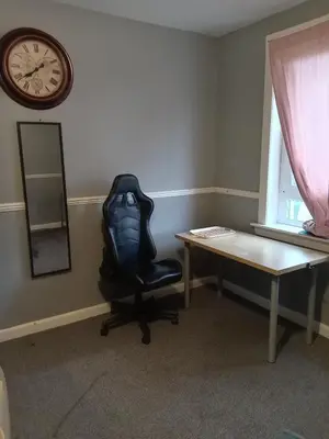 a office with a chair and a desk and a clock at Pokój 1osobowy in Moffat