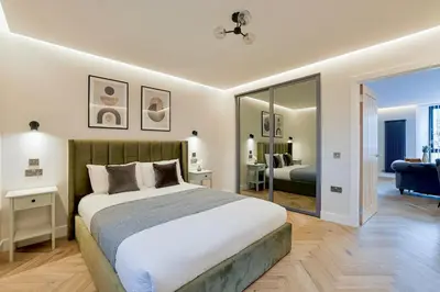 a bedroom with a large bed and a living room at Modern apartment in town centre in Oban