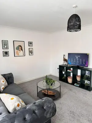 a living room with a couch and a tv at 2BR Flat Free Parking Near Hampden and O2 Academy in Glasgow