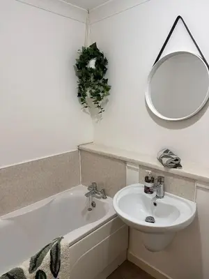 a bathroom with a sink and a mirror and a bath tub at 2BR Flat Free Parking Near Hampden and O2 Academy in Glasgow
