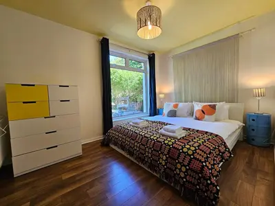 a bedroom with a bed with a dresser and a window at The Robin House in Ravelston in Edinburgh