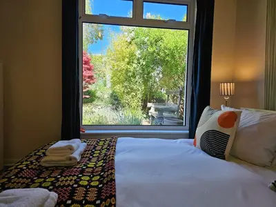 a bedroom with a bed and a large window at The Robin House in Ravelston in Edinburgh