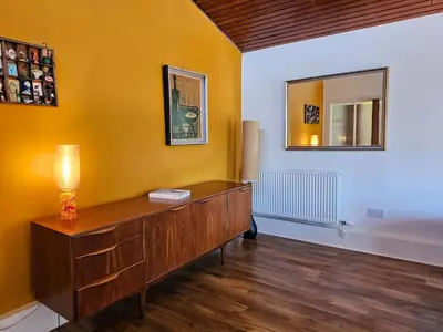 a room with a wooden dresser and a mirror at The Robin House in Ravelston in Edinburgh