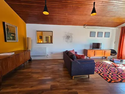 a living room with a couch and a desk at The Robin House in Ravelston in Edinburgh