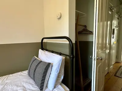 a bed with a black and white pillow on it at Grindlay St - Fantastic 2BR in Theatre District in Edinburgh
