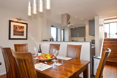 a dining room table with a bowl of fruit on it at Cliff Top - Bubbling Springs in Wemyss Bay