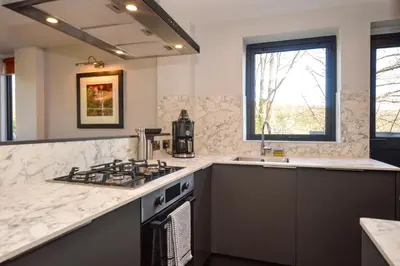 a kitchen with a stove and a sink at Cliff Top - Bubbling Springs in Wemyss Bay
