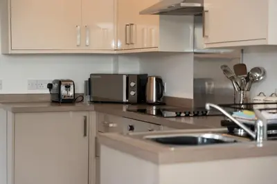 a kitchen with a sink and a microwave at Glenfiddich Apartment in Oban