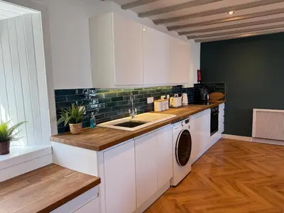 a kitchen with a sink and a washing machine at Eldon Cottage in Isle of Arran