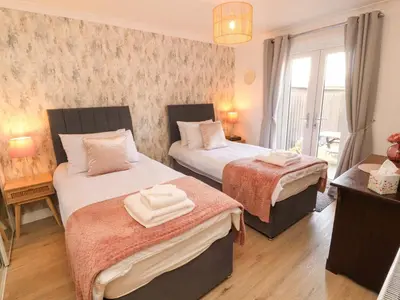 a bedroom with two beds with towels on them at The Paddock in Kirkcowan