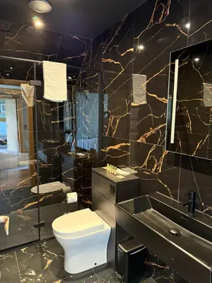 a bathroom with a toilet and a sink and a mirror at Oban House House in Oban