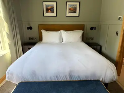 a bed with white sheets and pillows in a room at Oban House House in Oban