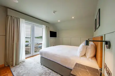 a bedroom with a large bed and a large window at Oban House House in Oban
