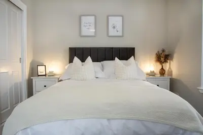 a bedroom with a large white bed with white pillows at Cottage in Crieff in Crieff
