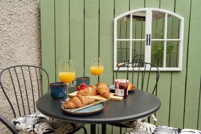 a black table with two glasses of orange juice and croissants at Cottage in Crieff in Crieff