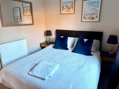 a bedroom with a large bed with blue pillows at South Gyle House - SuperFast WiFi and Free Parking - 7 minutes from Edinburgh Airport in Edinburgh
