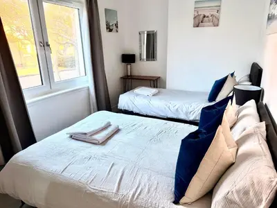 a bedroom with two beds and a window at South Gyle House - SuperFast WiFi and Free Parking - 7 minutes from Edinburgh Airport in Edinburgh