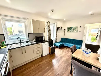 a kitchen and living room with a blue couch at South Gyle House - SuperFast WiFi and Free Parking - 7 minutes from Edinburgh Airport in Edinburgh