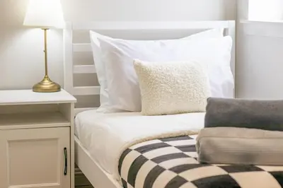 a bed with white pillows and a table with a lamp at Alexandra Apartment - Single Room #1 in Falkirk