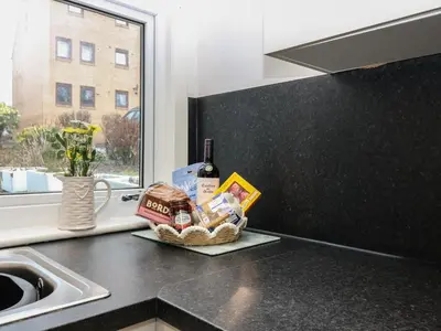 a kitchen counter with a basket of food and a bottle of wine at 60E Wellgate in Lanark