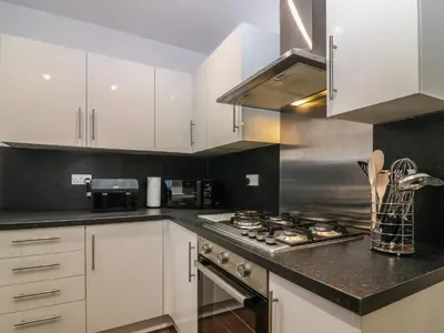 a kitchen with white cabinets and a stove top oven at 60E Wellgate in Lanark