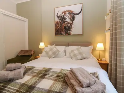a bedroom with a large white bed with two pillows at 60E Wellgate in Lanark