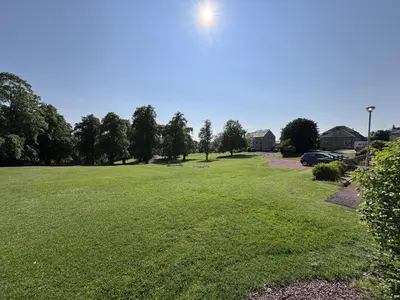 a large grassy field with a car parked in it at 60E Wellgate in Lanark