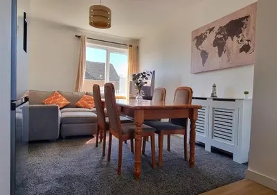 a living room with a table and chairs and a couch at Stylish Coastal Retreat in Saltcoats in Stevenston