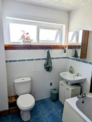 a bathroom with a toilet and a sink at Stylish Coastal Retreat in Saltcoats in Stevenston