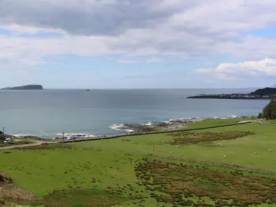 a green field with a view of the ocean at Bathach Mor in Oban