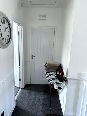 a white hallway with a chair and a clock at Luxury House in Glasgow in Mansewood