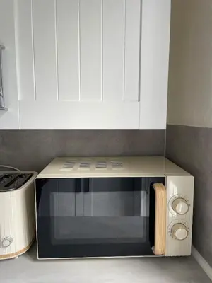 a microwave oven in a kitchen with white cabinets at Luxury House in Glasgow in Mansewood