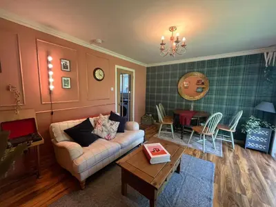 a living room with a couch and a table at Coastal Village Property in Inverkip