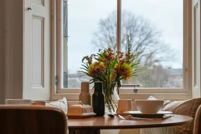 a table with a vase of flowers and a window at Merchiston 1 Room in Shared Apartment with Parking - Edinburgh in Edinburgh