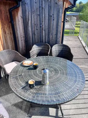 a glass table on a deck with two cups on it at 6, The Gallops, Mains of Taymouth Estate, Kenmore in Kenmore