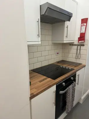 a kitchen with white cabinets and a stove top oven at 52, Charlotte Street Apartments in Glasgow