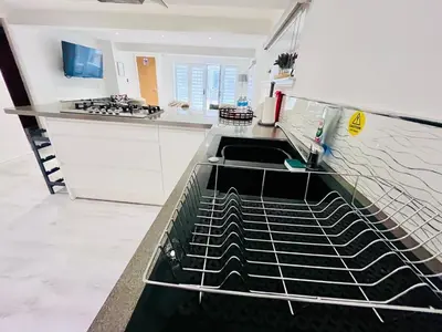 a kitchen with a sink and a dishwasher at Unique Modern Studio Apartment in Motherwell