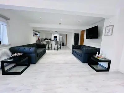 a living room with two blue couches and a kitchen at Unique Modern Studio Apartment in Motherwell
