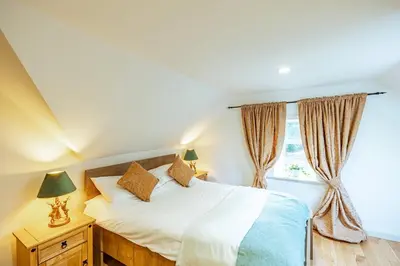 a bedroom with a bed and a window at Penninghame Estate - West Lodge in Challoch