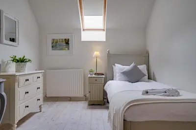 a bedroom with two beds and a dresser at Penninghame Estate - Wallace Apartment in Challoch
