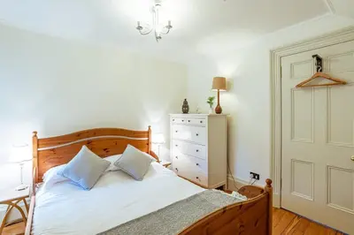 a bedroom with a bed and a dresser and a lamp at Penninghame Estate - Stewart Apartment in Challoch