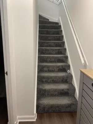 a staircase in a home with grey carpet at Millview house in Airdrie