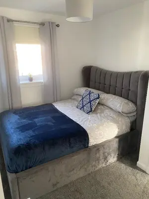 a bed in a room with a couch and a window at Millview house in Airdrie