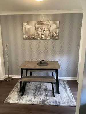 a table with a bench on a rug in a room at Millview house in Airdrie