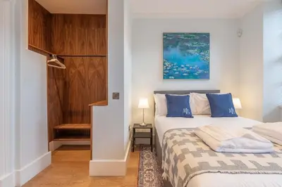 a bedroom with a bed with blue pillows at Wemyss Hideaway Retreat in Edinburgh
