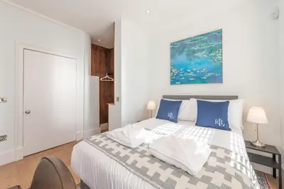 a bedroom with a large bed with blue pillows at Wemyss Hideaway Retreat in Edinburgh