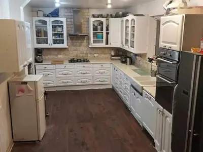 a large white kitchen with white cabinets and appliances at Silverknowes in Edinburgh