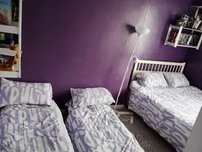 a bedroom with two beds and a purple wall at Silverknowes in Edinburgh